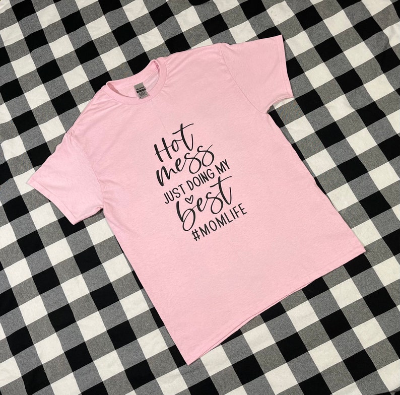 May include: Pink t-shirt with black text that reads "Hot mess just doing my best #momlife".