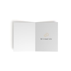 May include: A white card with a gold puzzle piece icon and the text "We're meant to be."