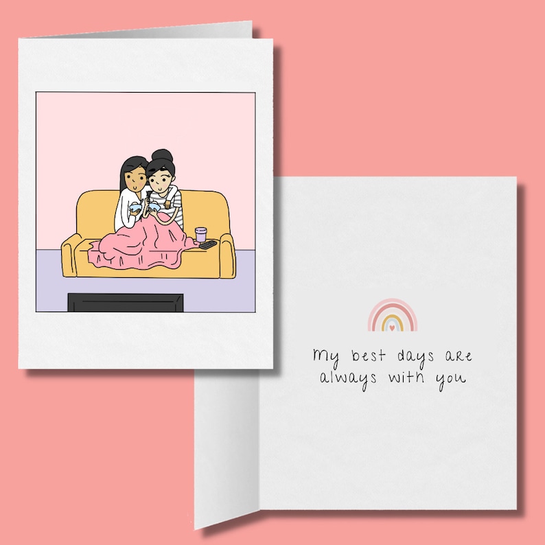 K&ouml;nnte beinhalten: Eine Gru&szlig;karte mit einer Cartoon-Illustration von zwei Personen auf einem Sofa unter einer Decke, die Videospiele spielen. Die Innenseite der Karte lautet "Meine besten Tage sind immer mit dir" mit einem Regenbogen-Motiv &uuml;ber dem Text.