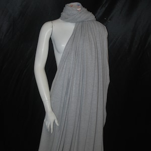 May include: A gray jersey knit fabric draped over a mannequin. The fabric is soft and has a slight sheen.