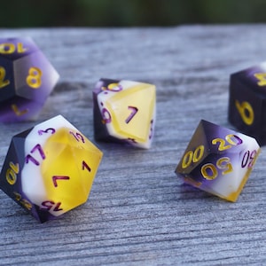May include: A collection of polyhedral dice in various shapes, including D4, D6, D8, D10, D12, and D20. The dice feature a gradient design with purple, yellow, and white colors, and gold-colored numbers. The dice are arranged on a weathered wooden surface.