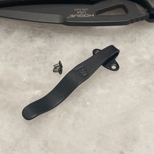 May include: Black pocket clip with three screws and the text "USA" and a small American flag design.