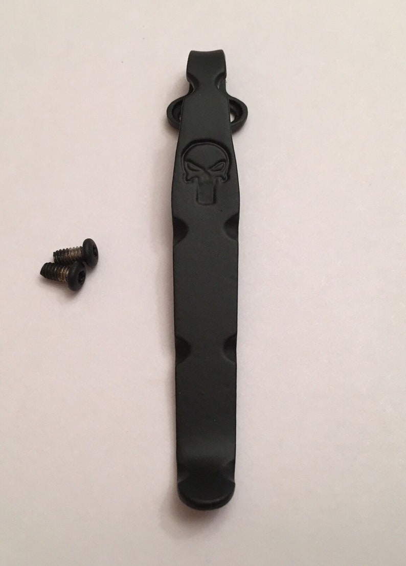 Pu&ograve; includere: Portachiavi in metallo nero con un design a forma di teschio. Il clip &egrave; fissato a un portachiavi con due viti.