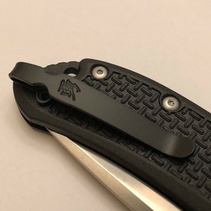 May include: Black pocket knife with a textured handle and a silver blade. The knife has a black pocket clip with the word "ZERO" engraved on it.