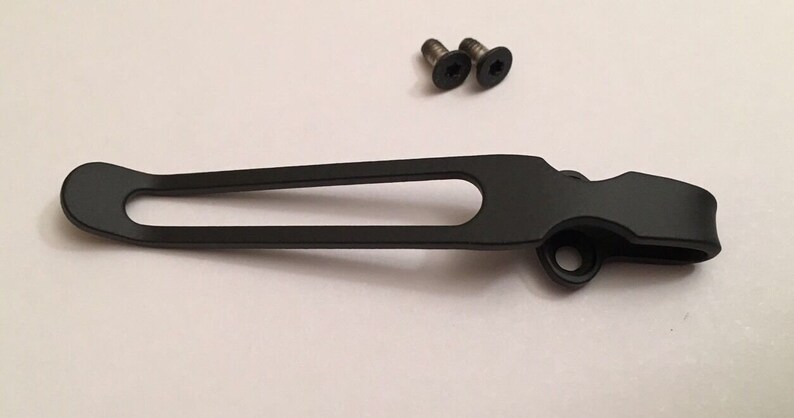May include: Black metal pocket clip with two screws. The clip is designed to attach to a pocket or belt.