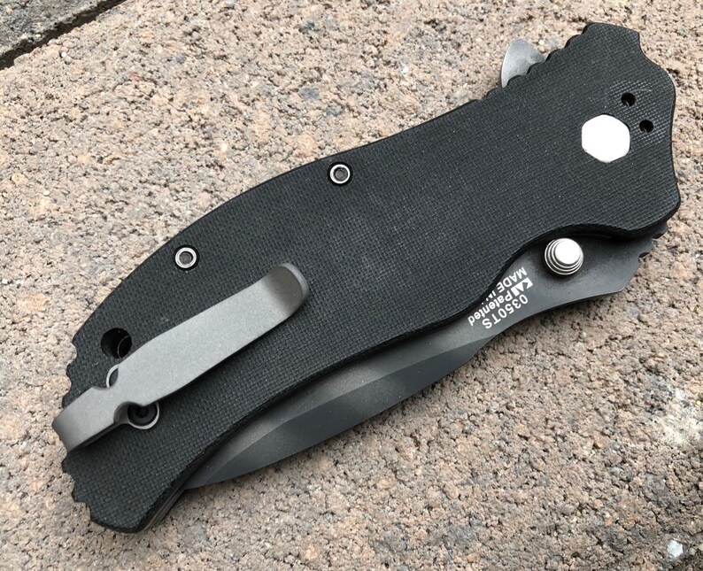 May include: Black pocket knife with a black handle and a silver clip. The knife has a textured handle and a silver blade. The knife is made in the USA and has the model number 03501S.