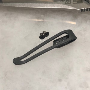 May include: A black metal pocket clip with two screw holes. Two small black screws are included.