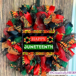 May include: A red, green, black, and yellow patterned wreath with a sign that reads "Happy Juneteenth".
