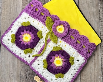 May include: A crocheted purple and white flower design with a yellow center. The crocheted piece is attached to a yellow fabric lining.