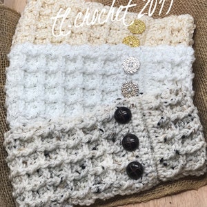 May include: Three crocheted headbands with different textures and colors. The top headband is beige, the middle headband is white with a sparkly finish, and the bottom headband is a cream color with black flecks. Each headband has a button closure.