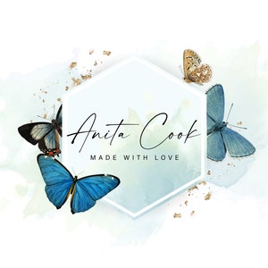 May include: A logo design featuring the name "Anita Cook" in elegant script within a white and light blue hexagon. The design includes watercolor butterflies in shades of blue, brown, and black, with gold accents and the text "MADE WITH LOVE".