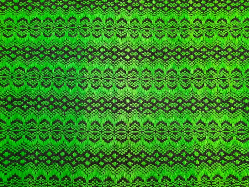 May include: Green and black fabric with a repeating geometric pattern. The pattern is made up of small circles and diamonds.