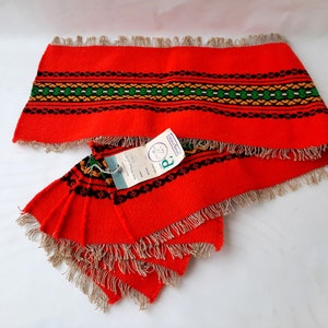 Pu&ograve; includere: Set di sei tovagliette all'americana in tessuto rosso con un motivo geometrico nero, verde e giallo. Le tovagliette hanno bordi a frangia e sono dotate di un'etichetta con la scritta "R" e "Made in Holland".