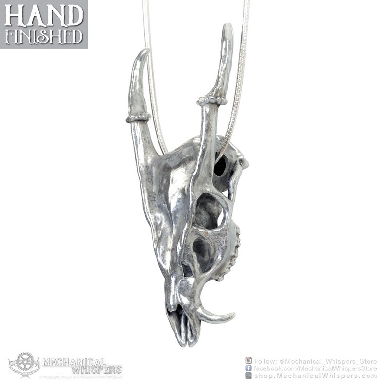 Muntjac deer skull pendant, highly detailed, designed from a 3D scan of an actual muntjac skull. Available in 3 metals: blackened steel, brass with a custom patina, and sterling silver with custom patina. 50mm tall.