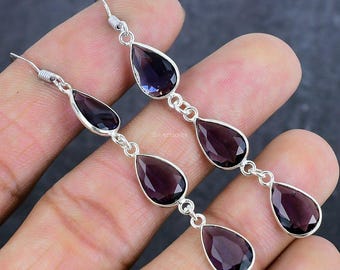 May include: A pair of sterling silver dangle earrings featuring three teardrop-shaped amethyst gemstones. The earrings are approximately 5 cm long.