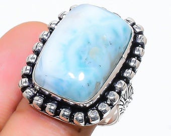 Könnte beinhalten: Ein silberner Ring mit einem großen, hellblauen und weißen Edelstein. Der Ring hat ein Perlenmuster um den Edelstein.
