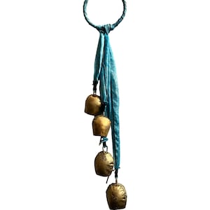 Pode incluir: Um tassel de tecido azul com quatro sinos dourados pendurados em um anel de metal.