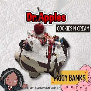 May include: A white ceramic piggy bank shaped like a pig with chocolate and white frosting, sprinkles, and a red cherry on top. The piggy bank is labelled "Cookies N Cream" and "Piggy Banks".