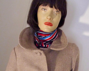 May include: A beige wool coat with a large collar and three buttons. The coat is worn by a mannequin with black hair and a red, white, and blue striped scarf.