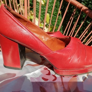 Peut inclure: Une paire de talons hauts plateforme rouges avec un talon épais. Les chaussures sont en cuir et ont une pointe fermée.