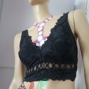 May include: Black lace bralette with a V-neckline and a band of decorative circles around the bottom.