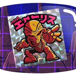 May include: A holographic sticker featuring a stylized robot character in shades of red and gold, with Japanese text. The robot has a detailed design with a helmet and outstretched hand, set against a blue and purple background.