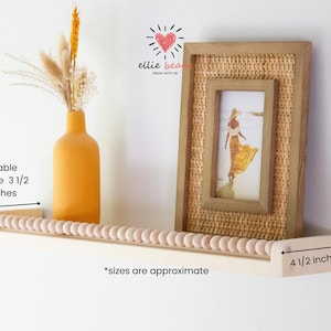 May include: A wooden shelf with a beaded edge, a framed picture, and a yellow vase with dried flowers. The shelf is 4.5 inches wide and 1.75 inches deep, with a usable space of 3.5 inches. The frame has a woven texture.