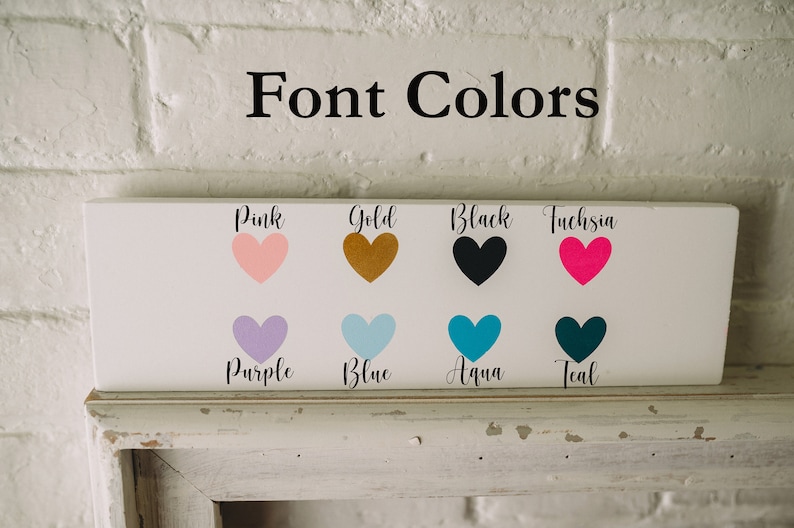 Op de afbeelding: Een wit bord met de tekst "Font Colors" bovenaan. Het bord toont acht hartvormen in verschillende kleuren: roze, goud, zwart, fuchsia, paars, blauw, aqua en teal. Elke hartvorm heeft de kleurnaam eronder.