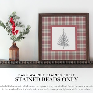 May include: A dark walnut stained shelf with stained beads, holding a framed print with a plaid pattern and a pine tree illustration. A small brown vase with red berries and green foliage is on the shelf. The text on the image reads: DARK WALNUT STAINED SHELF STAINED BEADS ONLY.