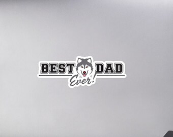 Könnte beinhalten: Ein weißer Laptop mit einem schwarz-weißen Aufkleber, auf dem "Best Dad Ever!" steht und in der Mitte des Textes ein Cartoon-Husky-Hundekopf zu sehen ist.