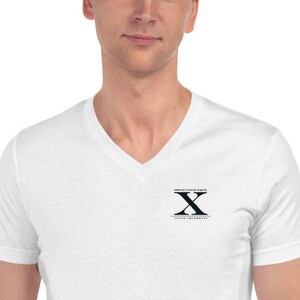 May include: White V-neck t-shirt with a black embroidered logo featuring the letter "X" and the text "TEXAS A&M UNIVERSITY".