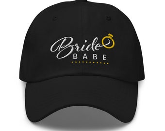 May include: Black baseball cap with white embroidery that says "Bride Babe" with a gold ring and diamond graphic.