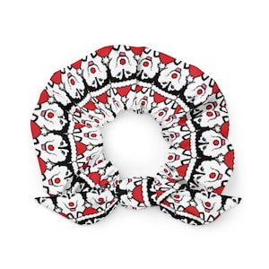 May include: A white and red scrunchie with a repeating pattern of white dogs wearing Santa hats.