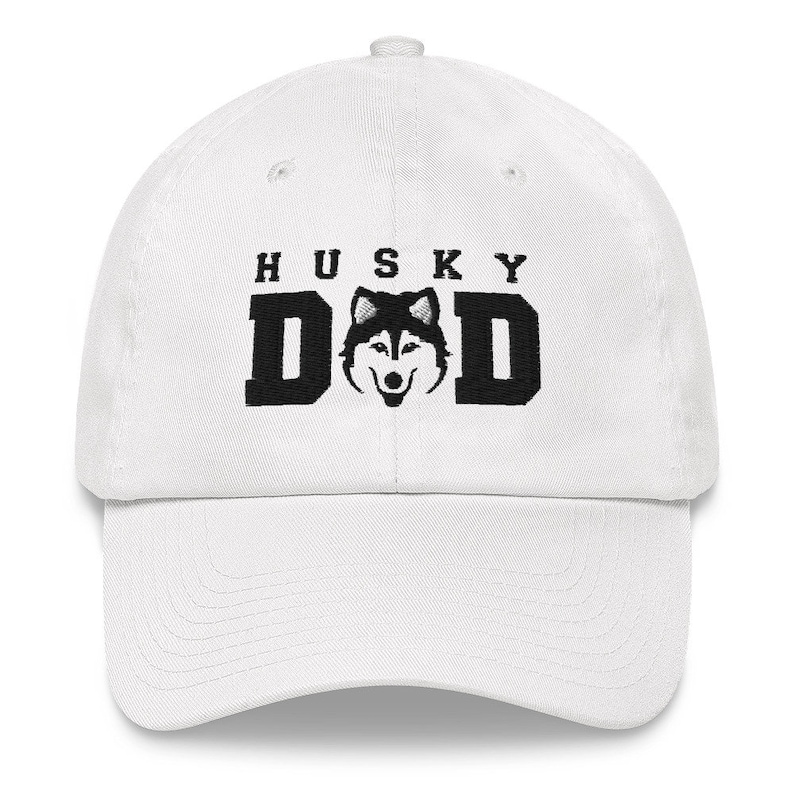 May include: White baseball cap with black embroidery that reads "Husky Dad" and features a black and white husky silhouette.