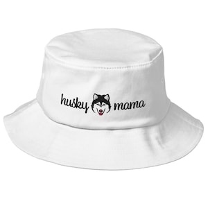 May include: White bucket hat with black embroidery that reads "husky mama" and features a black and white husky face.