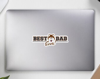 Könnte beinhalten: Ein Aufkleber mit dem Kopf eines braunen und weißen Husky-Hundes und dem Text "BEST DAD EVER!" in schwarzen und goldenen Buchstaben.