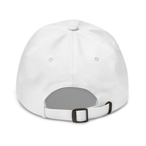 May include: A white baseball cap with a brown adjustable buckle closure.