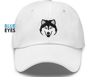 Peut inclure: Casquette de baseball blanche avec un visage de husky noir et blanc brodé avec des yeux bleus. Le nez du husky est rouge.