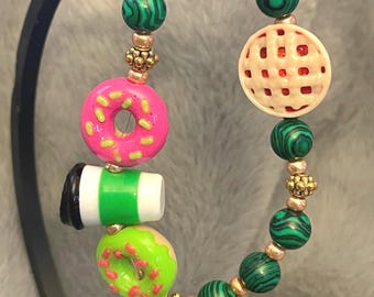 Green stone beads with gold hued accents with coffee, donuts and pie
