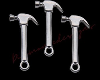 May include: Three silver-toned hammer charms with a loop at the bottom for attaching to jewelry or other crafts.