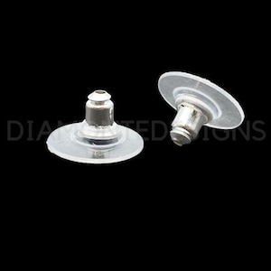 May include: Two clear plastic earring backs with a silver metal post. The backs are designed to be placed over the post of an earring to secure it in place.
