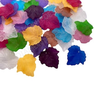 May include: Assortment of colourful glass leaf beads. The beads are translucent and have a variety of colours, including purple, pink, yellow, green, blue, and white.