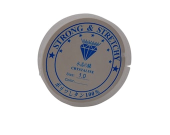 May include: A white spool of strong and stretchy elastic cord with a blue label that reads "STRONG & STRETCHY" with a diamond logo and the text "CRYSTALINE" and "Size: 1.0". The label also includes the text "ボリワレタン100%" in Japanese.