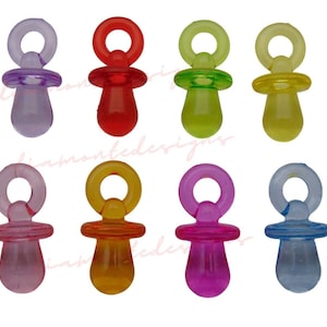 Puede incluir: Ocho abalorios de chupete de bebé de plástico de colores con un lazo en la parte superior. Los abalorios son de color morado, rojo, verde, amarillo, rosa, naranja, magenta y azul.