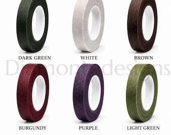 May include: Six rolls of floral tape arranged in two rows, featuring colors dark green, white, brown, burgundy, purple, and light green. Each roll has a textured surface and a white plastic core. The text Diamond designs is visible in the center.