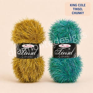 May include: Two balls of King Cole Tinsel Chunky yarn, one in metallic gold and one in metallic teal. Each ball features a black paper label with the text King Cole Tinsel chunky, featuring a crown logo and decorative star and swirl graphics.