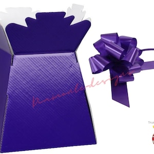 May include: A purple cardboard flower box with a white interior and a matching purple bow. The box is designed to hold flowers or other gifts.