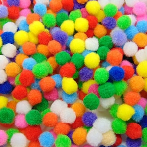 May include: A collection of multi-coloured pom-poms in shades of red, orange, yellow, green, blue, purple, pink, and white. These small, fluffy balls are scattered, creating a vibrant and playful texture, ideal for craft projects.