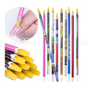 May include: Set of 10 nail art tools with yellow tips and colourful patterned handles. The tools are used for nail art and design.