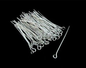 May include: A pile of silver-toned head pins with a loop at the end. The pins are arranged in a random pattern.